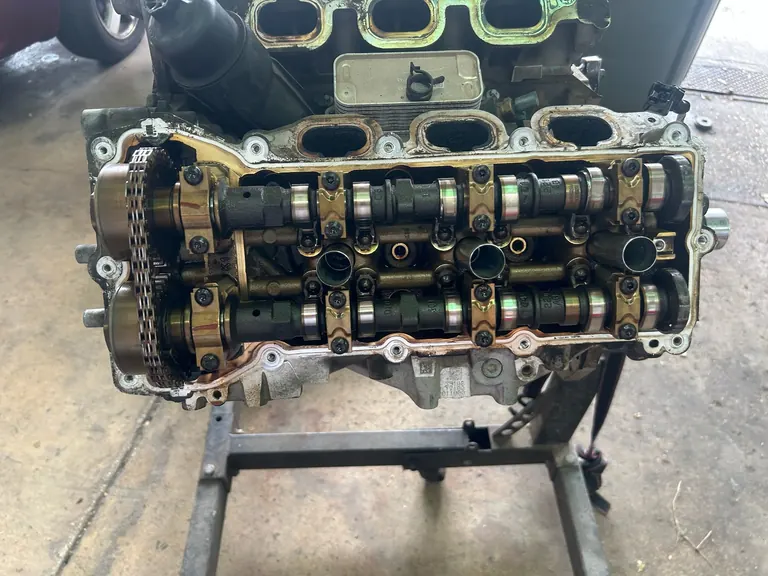 Top-down view of engine cylinder heads and camshafts on an engine stand in The Motorpool shop
